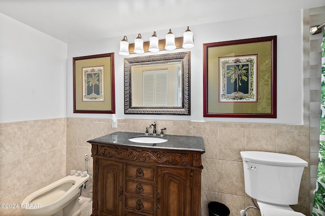 3370 Ocean Shore Blvd Unit 404B, Ormond Beach, FL 32176 - bathroom with tile walls, vanity, toilet, wainscoting, and a bidet
