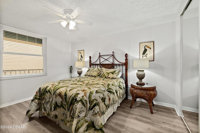 3370 Ocean Shore Blvd Unit 404B, Ormond Beach, FL 32176 - bedroom featuring a textured ceiling, wood finished floors, baseboards, ceiling fan, and a closet