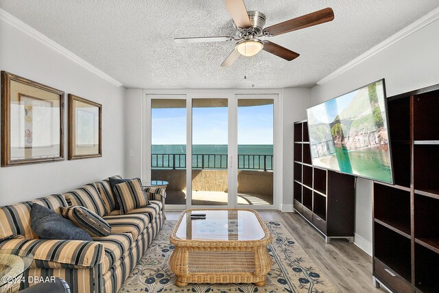 3370 Ocean Shore Blvd Unit 404B, Ormond Beach, FL 32176 - living room featuring light wood finished floors, a textured ceiling, a water view, ceiling fan, and ornamental molding