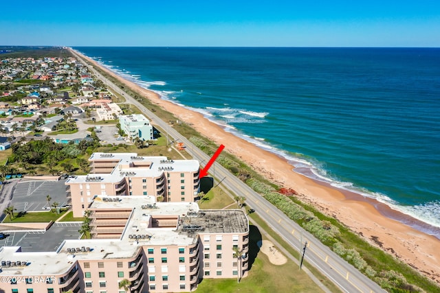 drone / aerial view with a water view and a beach view