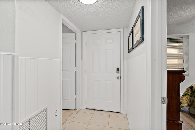 interior space with light tile patterned floors and a textured ceiling