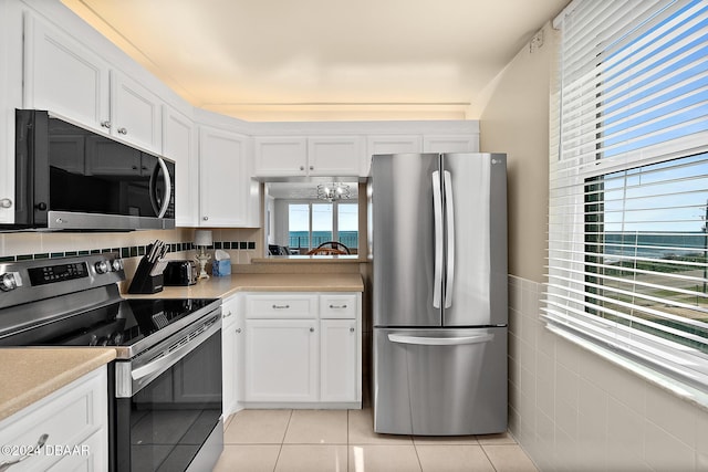 3370 Ocean Shore Blvd Unit 404B, Ormond Beach, FL 32176 - kitchen featuring stainless steel appliances, white cabinets, light tile patterned floors, and light countertops