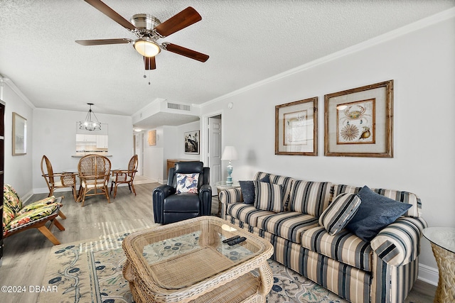 3370 Ocean Shore Blvd Unit 404B, Ormond Beach, FL 32176 - living room with light wood-style flooring, ceiling fan, a textured ceiling, ornamental molding, and baseboards