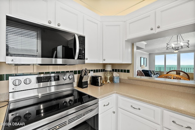 3370 Ocean Shore Blvd Unit 404B, Ormond Beach, FL 32176 - kitchen with stainless steel appliances, white cabinets, and light countertops