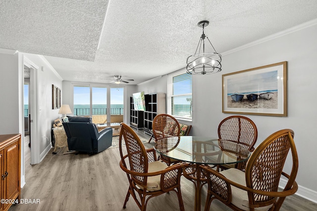3370 Ocean Shore Blvd Unit 404B, Ormond Beach, FL 32176 - dining area featuring a textured ceiling, crown molding, light wood-style floors, plenty of natural light, and a ceiling fan