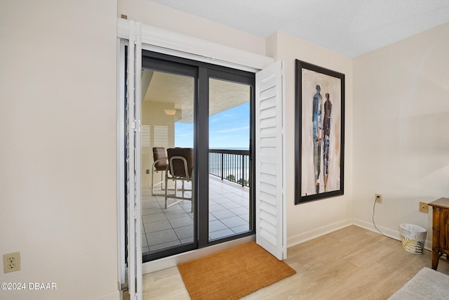 entryway featuring a textured ceiling and light hardwood / wood-style flooring