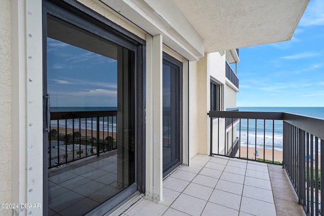 balcony featuring a beach view and a water view