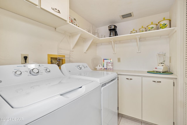 washroom with light tile patterned flooring, cabinets, and separate washer and dryer