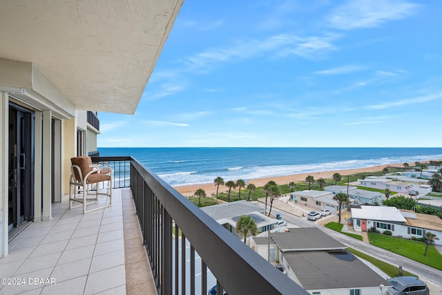 balcony featuring a water view and a beach view