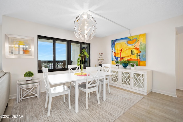 dining space featuring wood-type flooring and a chandelier