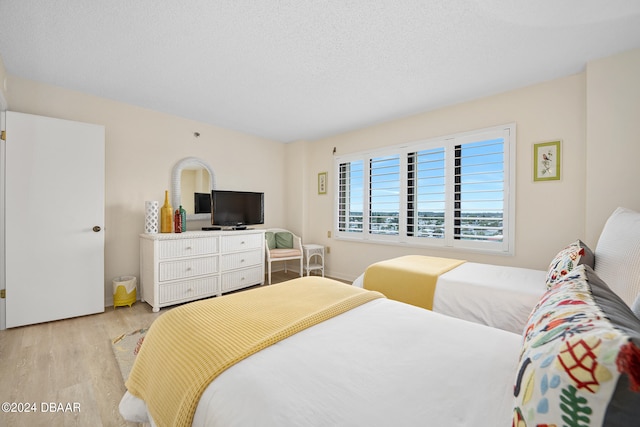 bedroom featuring light hardwood / wood-style floors and a textured ceiling