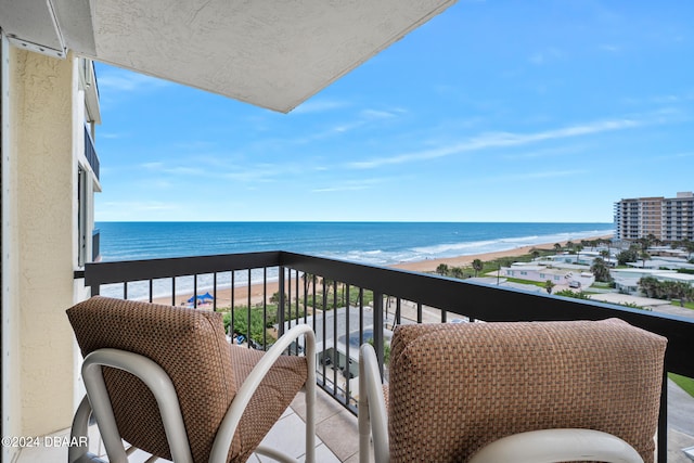 balcony featuring a view of the beach and a water view