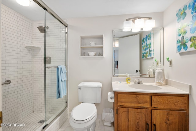 bathroom with vanity, tile patterned floors, toilet, and an enclosed shower