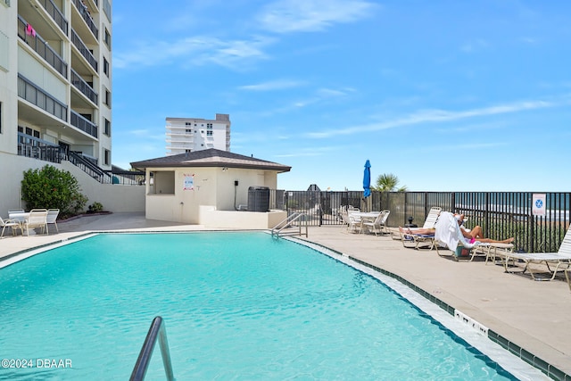 view of pool featuring central AC unit and a patio