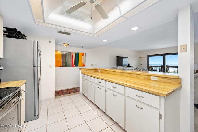 kitchen featuring light tile patterned flooring, white cabinetry, ceiling fan, and stainless steel appliances