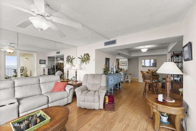 2987 S Atlantic Ave Unit 303, Daytona Beach, FL 32118 - living room featuring a ceiling fan, wood finished floors, plenty of natural light, and a textured ceiling