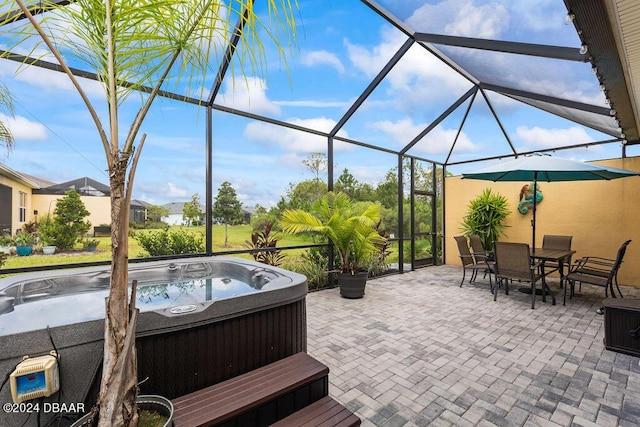 view of patio / terrace with a lanai and a hot tub