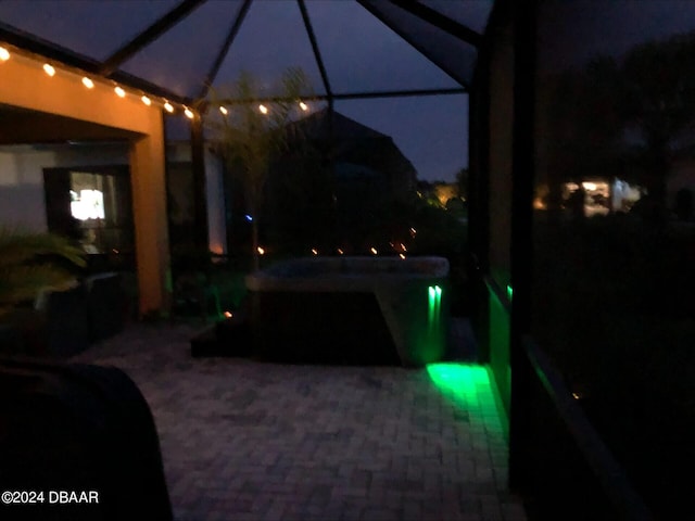 patio at night featuring a lanai