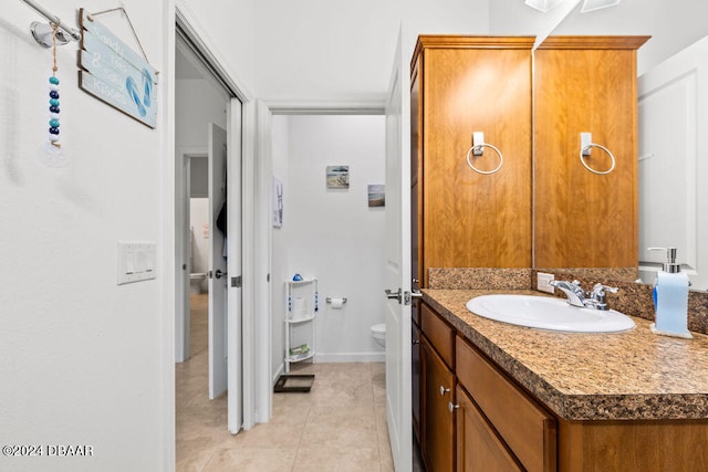 bathroom with tile patterned flooring, vanity, and toilet