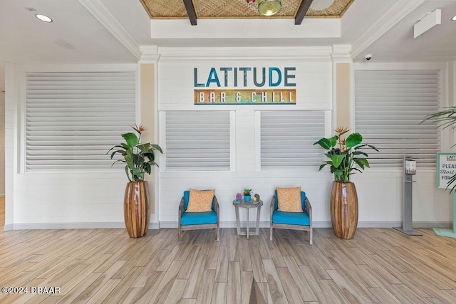 living area with ornamental molding and light wood-type flooring