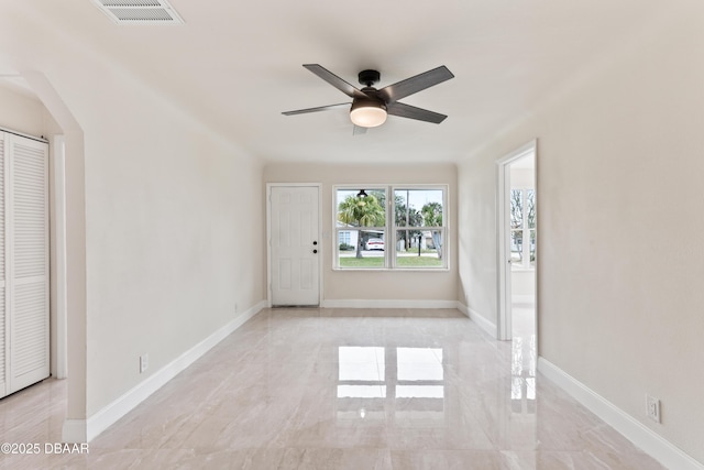 unfurnished room featuring marble finish floor, baseboards, visible vents, and ceiling fan