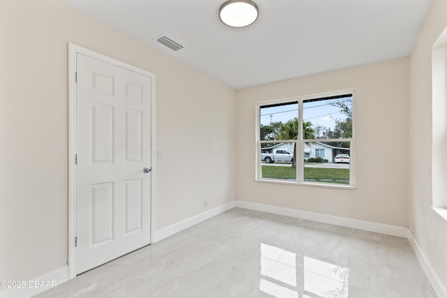 unfurnished room with visible vents and baseboards