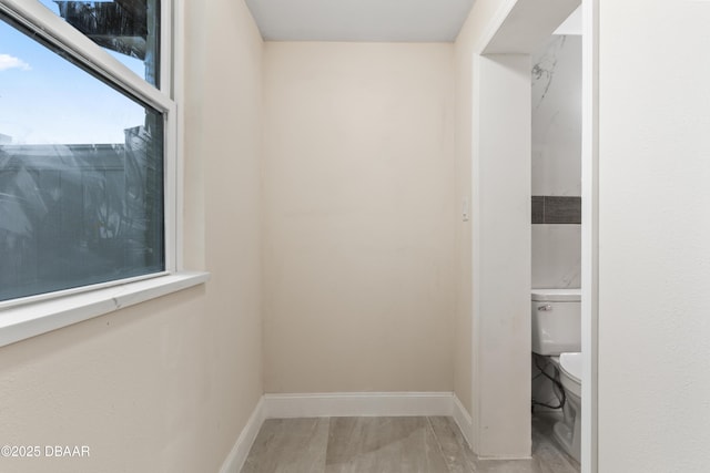 interior space with toilet and baseboards