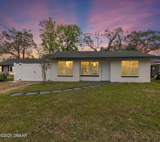 view of front of property with a lawn and fence