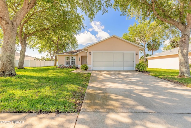 view of front of house with fence, a front lawn, stucco siding, an attached garage, and driveway