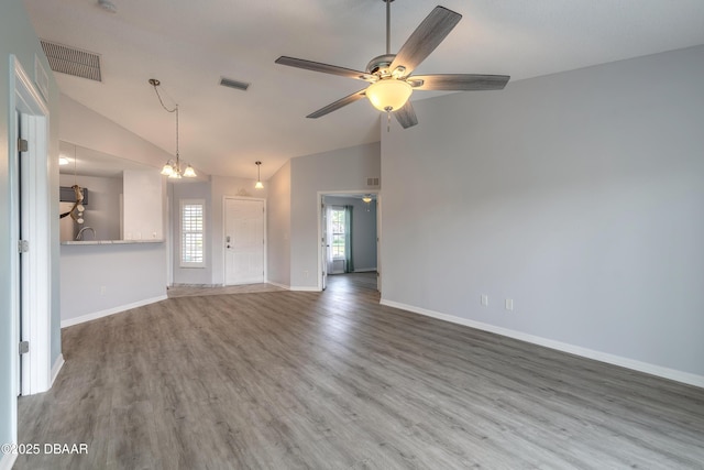 unfurnished living room with vaulted ceiling, wood finished floors, visible vents, and baseboards