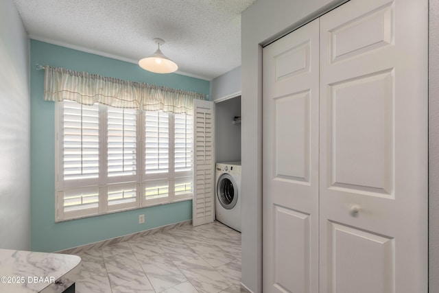 washroom with marble finish floor, a textured ceiling, laundry area, and washer / clothes dryer