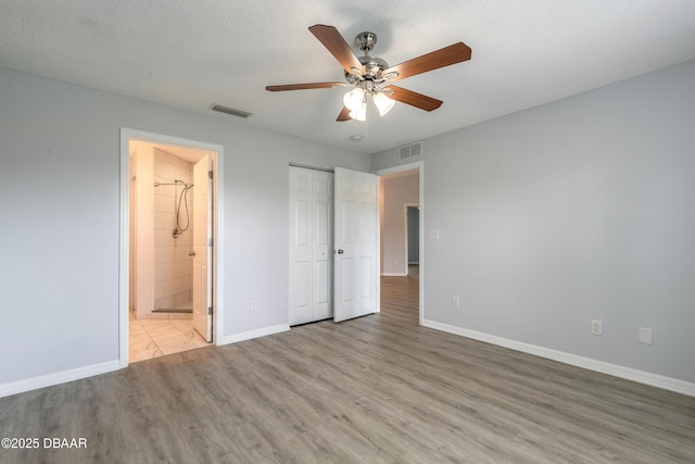 unfurnished bedroom featuring baseboards, light wood-style floors, and visible vents