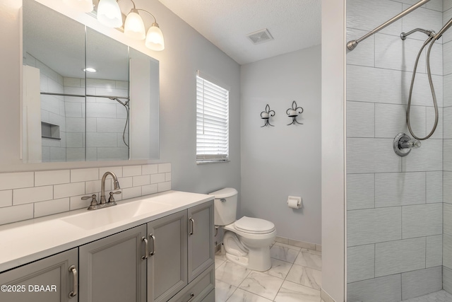 bathroom with marble finish floor, visible vents, toilet, vanity, and tiled shower