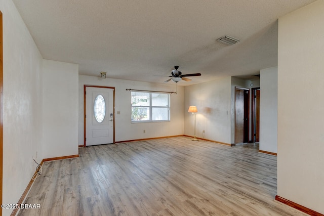 entrance foyer with ceiling fan, a textured ceiling, and light wood-type flooring