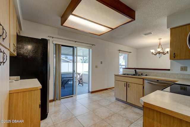 kitchen with sink, decorative light fixtures, a textured ceiling, light tile patterned floors, and appliances with stainless steel finishes