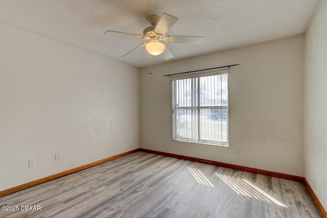 empty room with ceiling fan, a textured ceiling, and light wood-type flooring