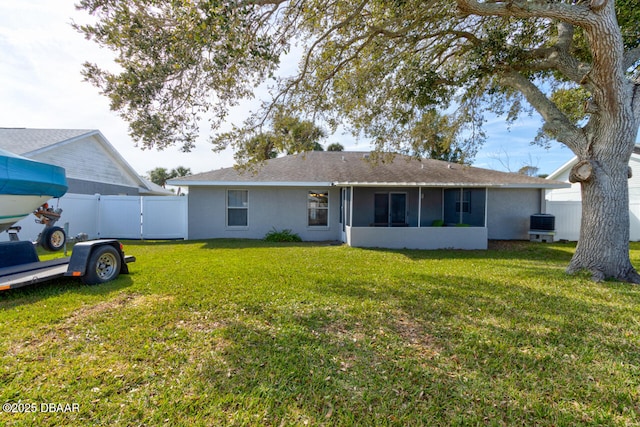 rear view of house featuring a lawn, a sunroom, and central air condition unit