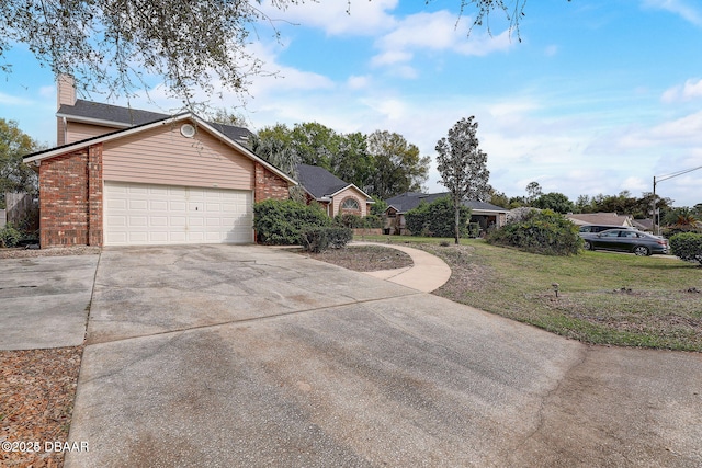 ranch-style house with a garage, brick siding, driveway, a chimney, and a front yard