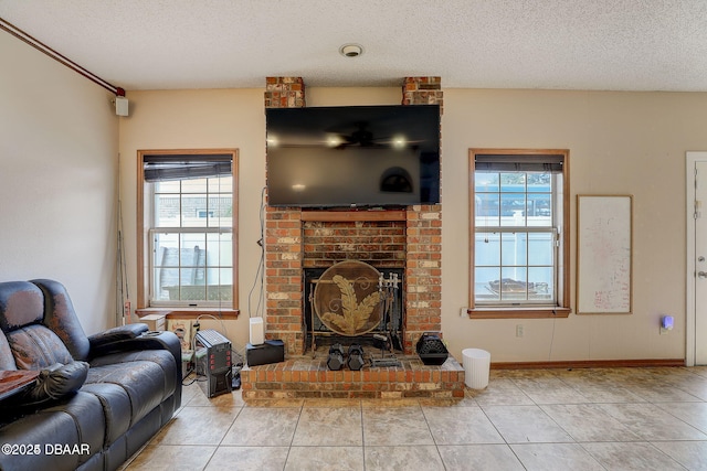 living area featuring a textured ceiling, a fireplace, baseboards, and tile patterned floors