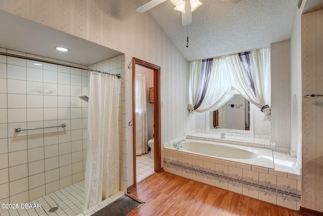 full bath featuring a textured ceiling, toilet, wood finished floors, a shower stall, and wallpapered walls