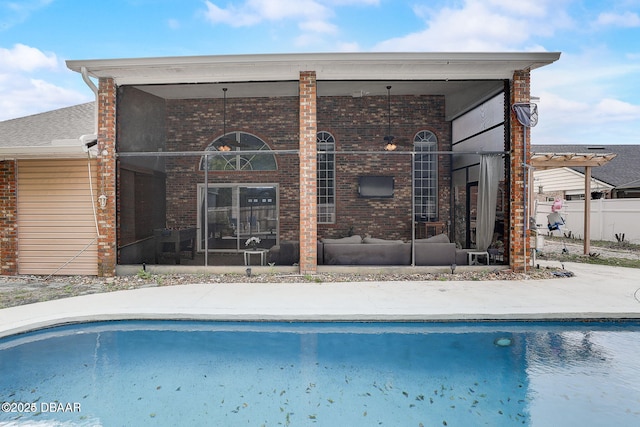 back of house with a sunroom, a fenced in pool, and brick siding