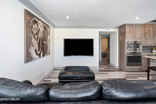 living room with a textured ceiling, light hardwood / wood-style flooring, and ornamental molding