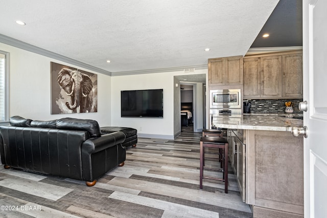 living room featuring bar, light hardwood / wood-style floors, and crown molding