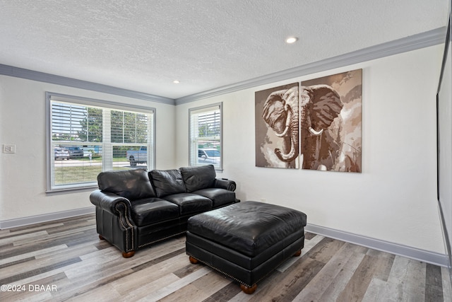 living room with a textured ceiling, wood-type flooring, a healthy amount of sunlight, and crown molding