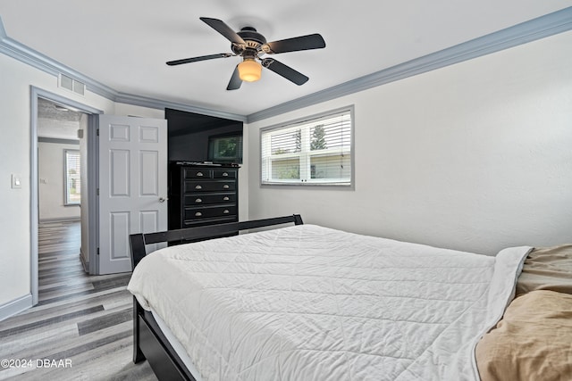 bedroom featuring light wood-type flooring, ceiling fan, and crown molding