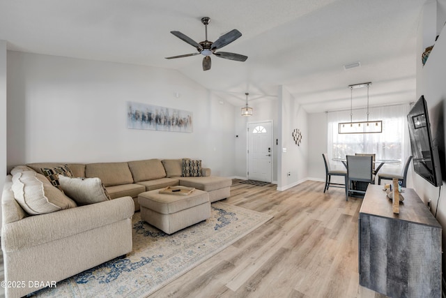 living room featuring a ceiling fan, visible vents, baseboards, light wood-style flooring, and vaulted ceiling