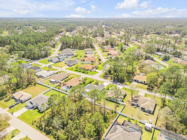 drone / aerial view with a wooded view and a residential view