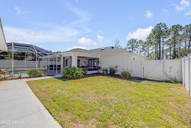 rear view of house with stucco siding, a gate, a patio, a fenced backyard, and a yard