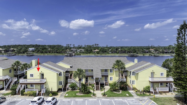 1101 Ocean Marina Dr Unit 201, Flagler Beach, FL 32136 - view of front facade with uncovered parking, a water view, and a chimney