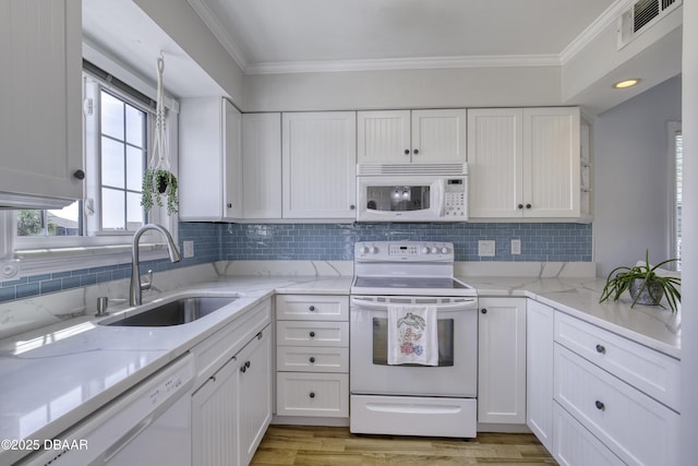1101 Ocean Marina Dr Unit 201, Flagler Beach, FL 32136 - kitchen with white appliances, a sink, white cabinetry, and ornamental molding